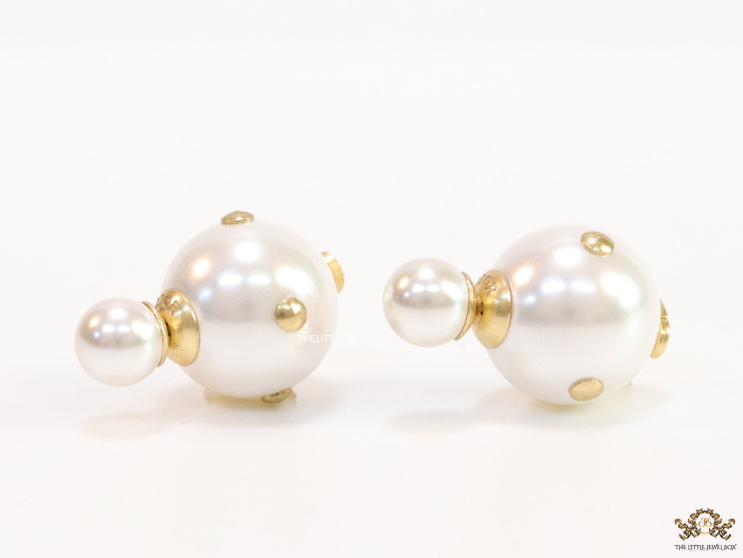 White pearl studs with golden alphabet motif and golden details