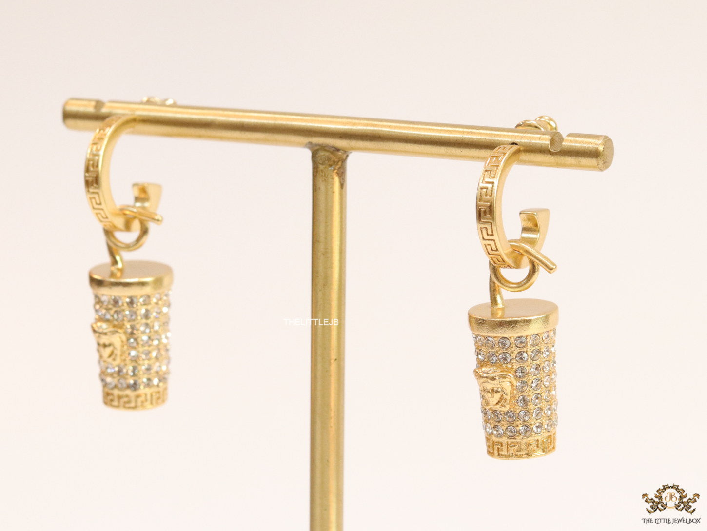 Gold plated hoop with cubic zirconia and 3d golden Medusa motif on cylidrical drop.