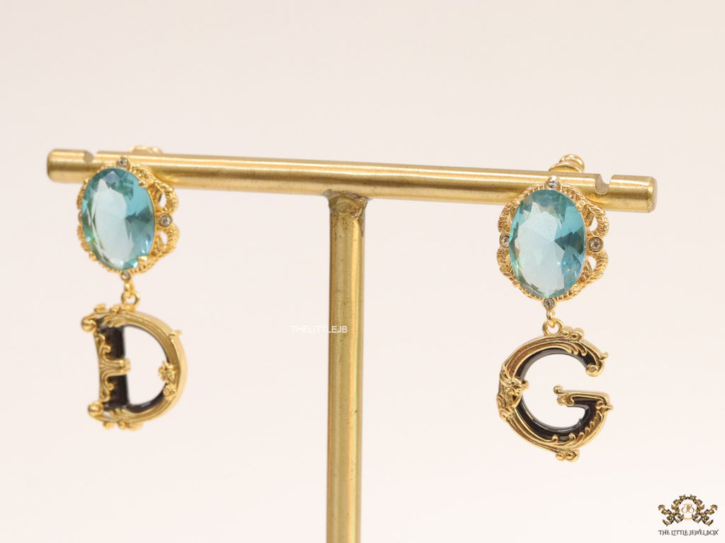 Semi-precious blue stone with gold plated detailed with black and golden alphabet drop