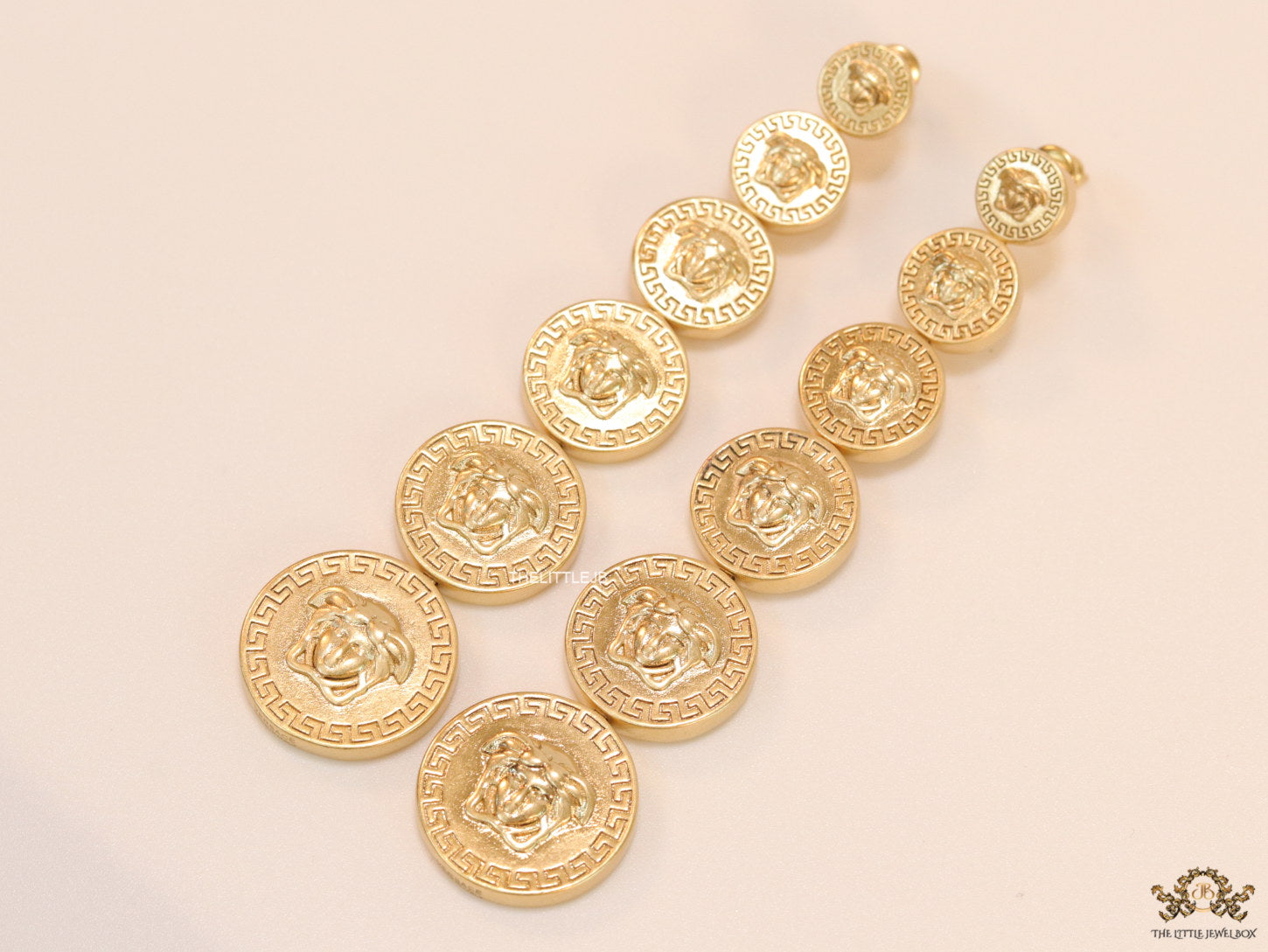 Gold plated embossed Medusa motif on golden circular base with golden details long chain studs