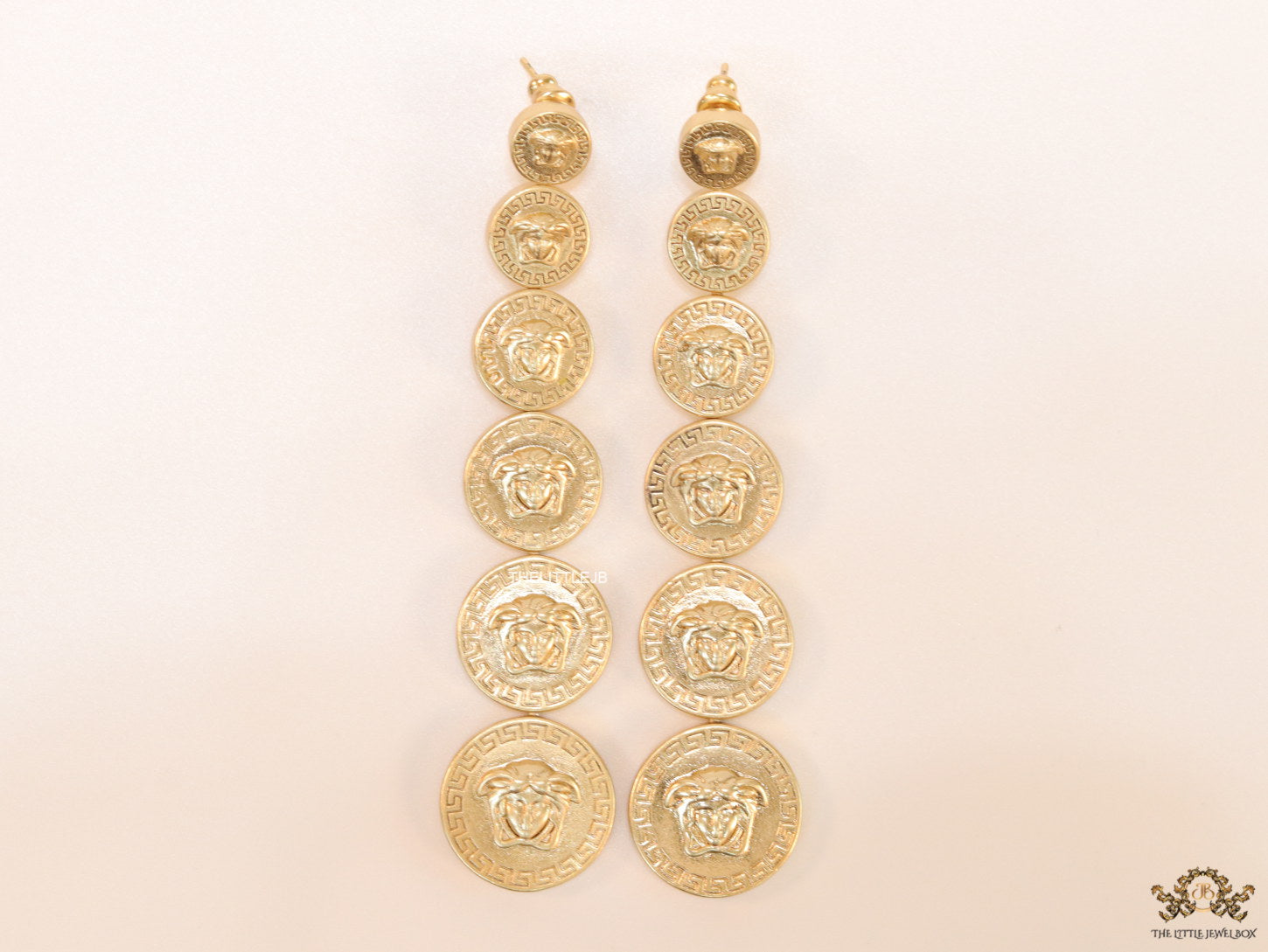 Gold plated embossed Medusa motif on golden circular base with golden details long chain studs