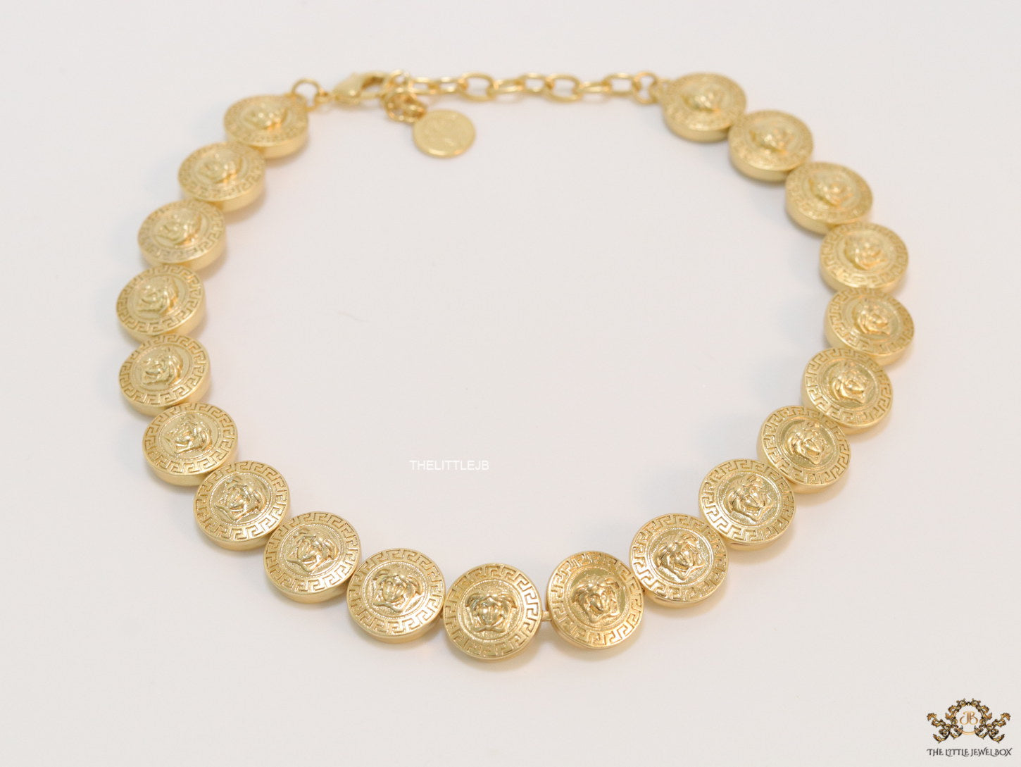 Gold plated embossed Medusa motif on gold circle base necklace