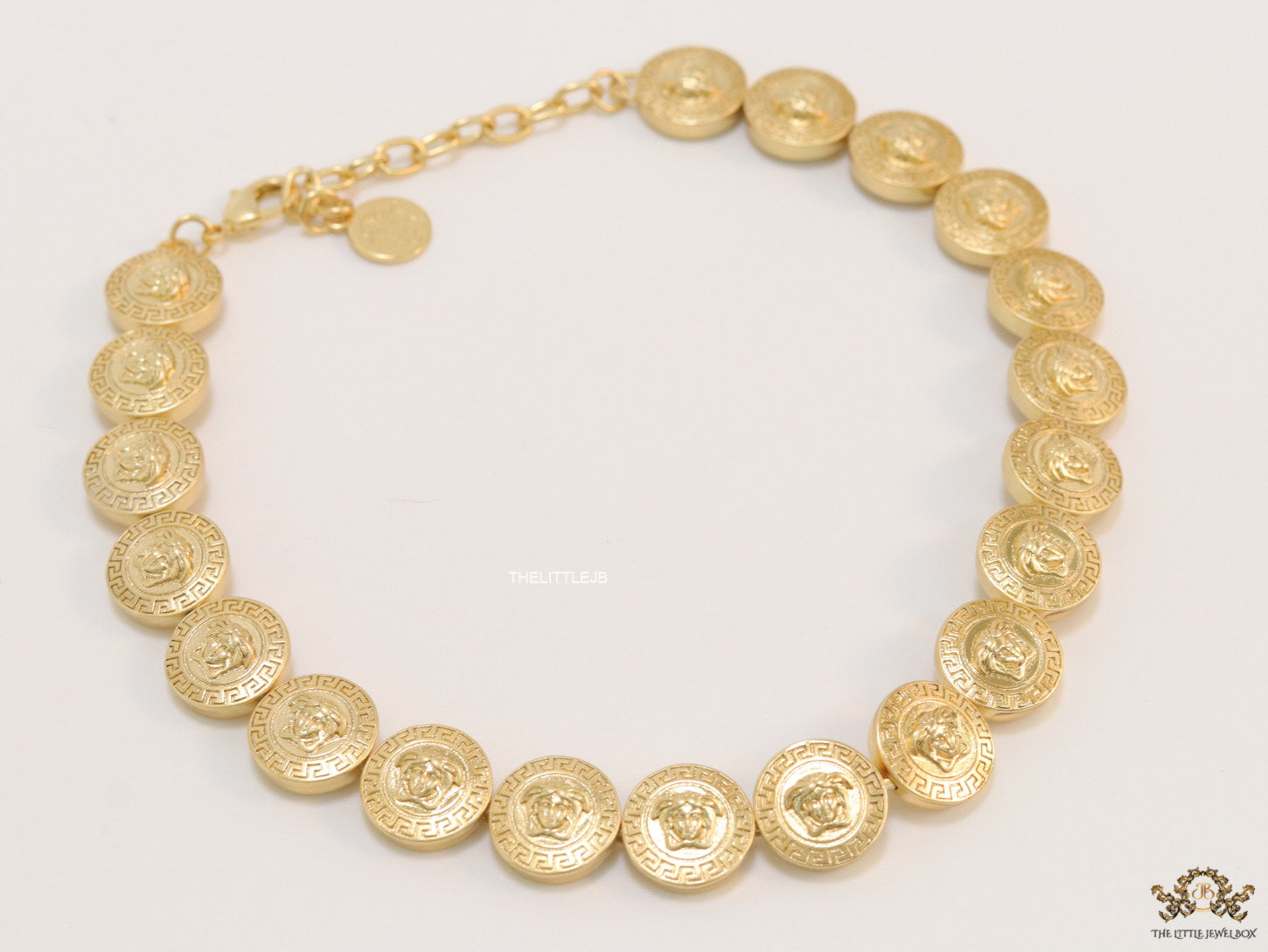 Gold plated embossed Medusa motif on gold circle base necklace
