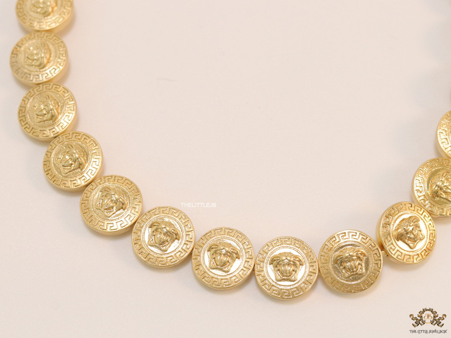 Gold plated embossed Medusa motif on gold circle base necklace