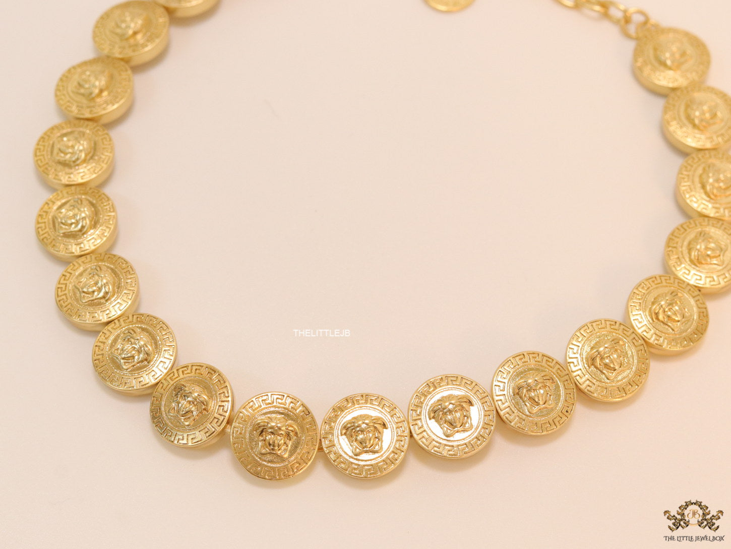 Gold plated embossed Medusa motif on gold circle base necklace