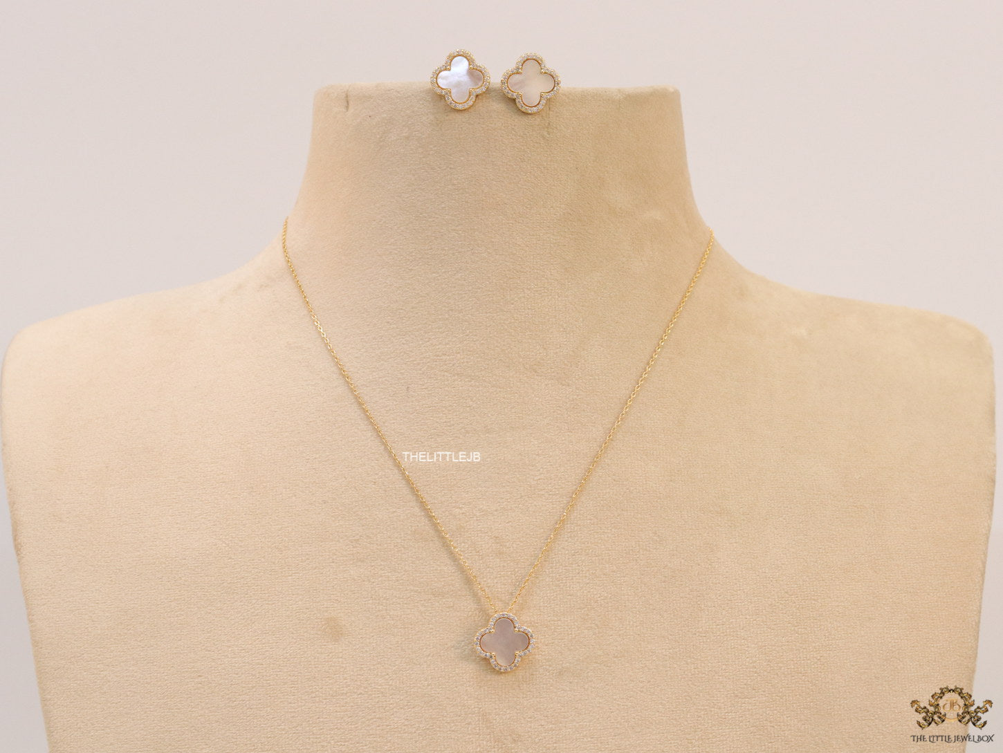 Sleek gold plated chain with cubic zirconia studded off-white clover shape pendant