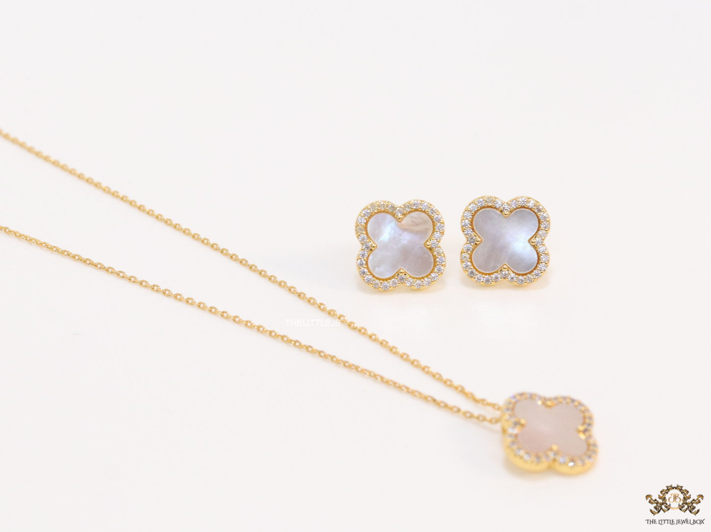 Sleek gold plated chain with cubic zirconia studded off-white clover shape pendant