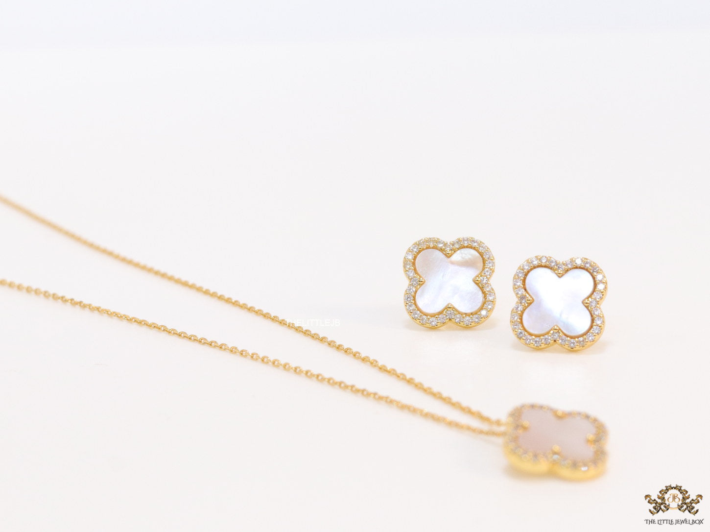 Sleek gold plated chain with cubic zirconia studded off-white clover shape pendant
