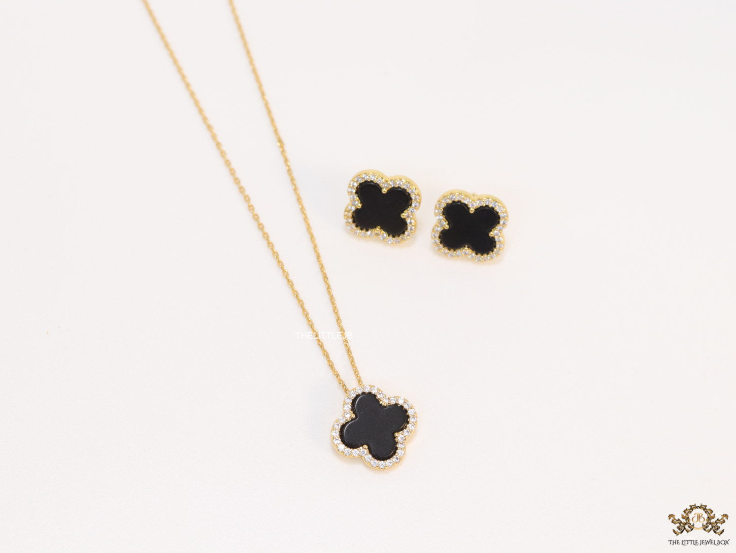 Sleek gold plated chain with cubic zirconia studded black clover shape pendant