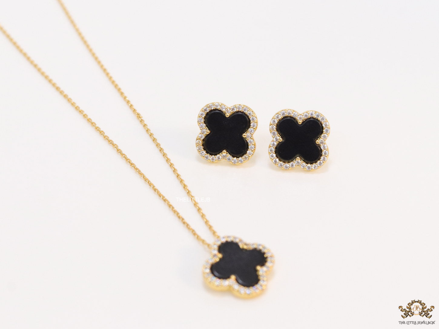 Sleek gold plated chain with cubic zirconia studded black clover shape pendant
