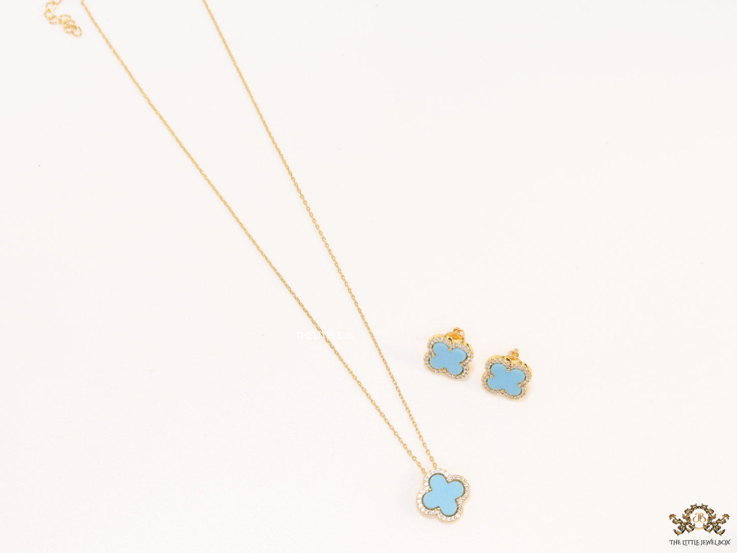 Sleek gold plated chain with cubic zirconia studded blue clover shape pendant