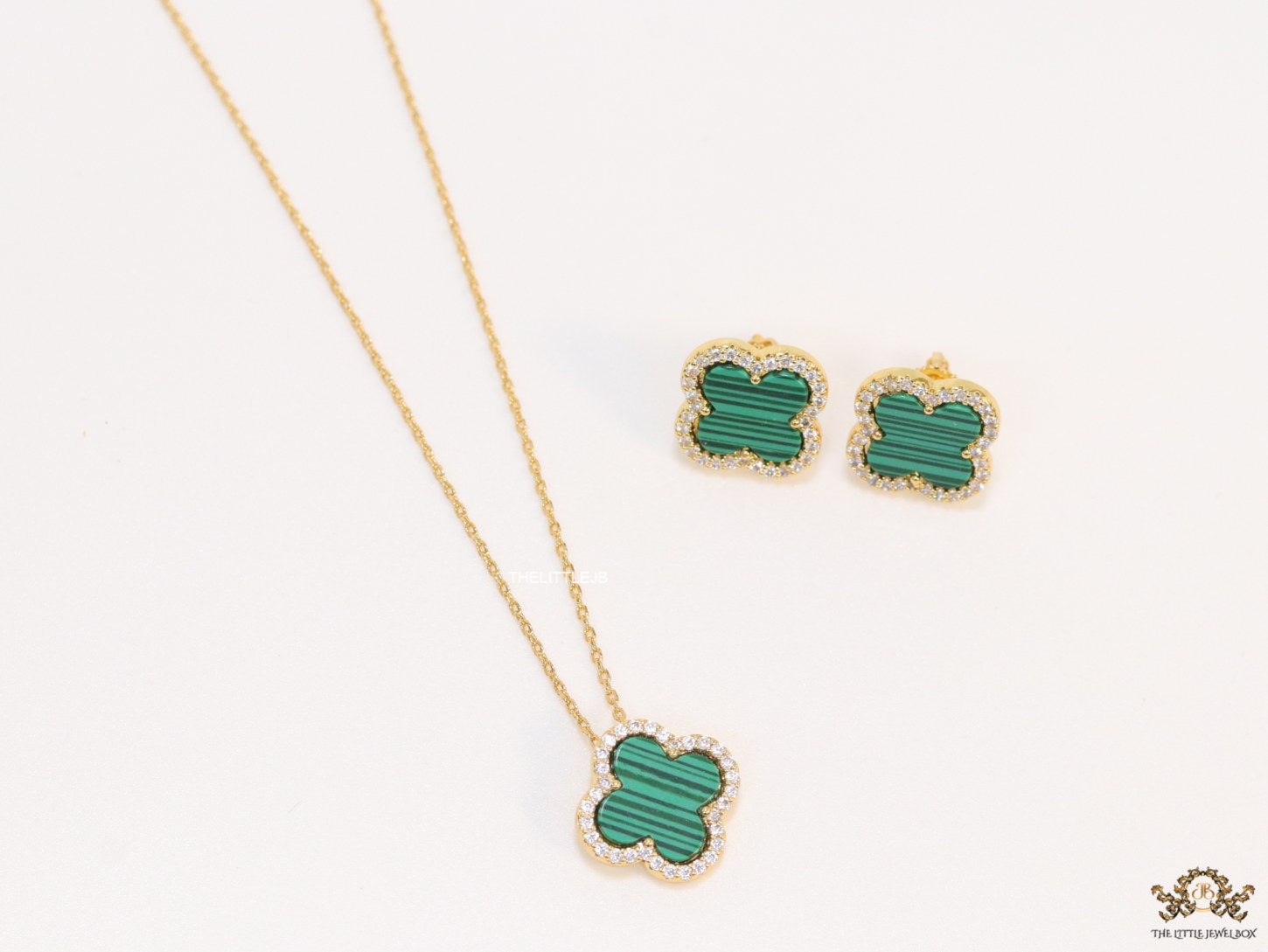Sleek gold plated chain with cubic zirconia studded green clover shape pendant