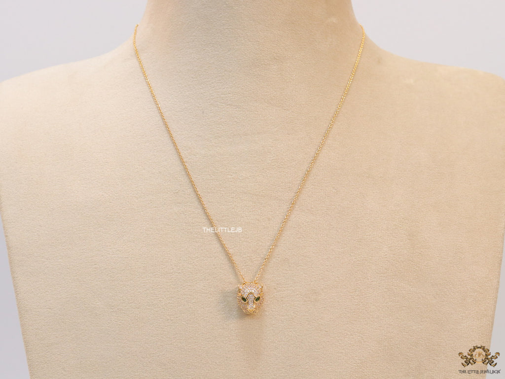 Gold plated cubic zirconia stones panther face motif pendant with emerald green stones details on sleek gold plated chain