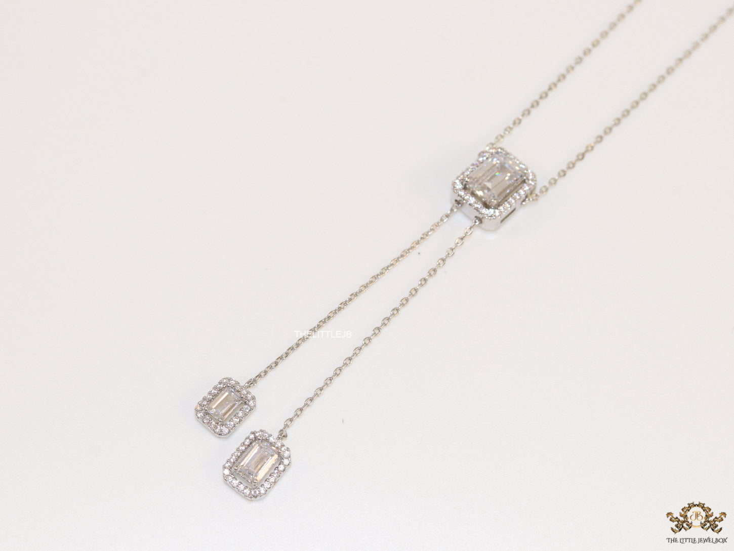 Emerald cut cubic zirconia stones in different sized on sleek platinum plated chain