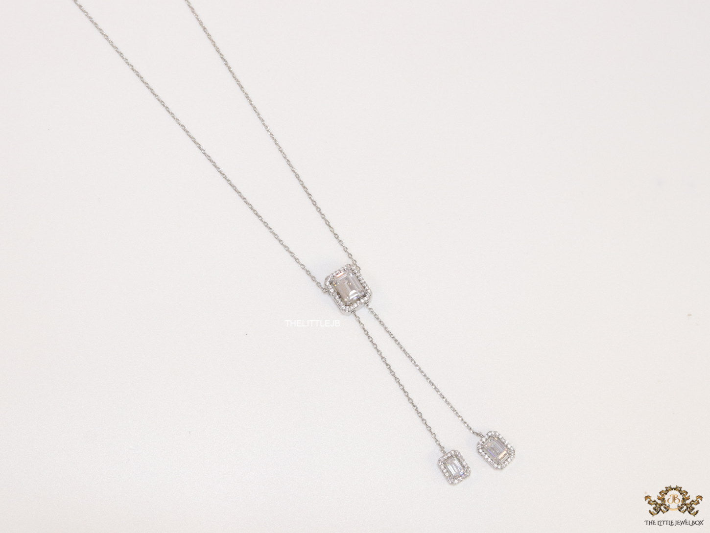 Emerald cut cubic zirconia stones in different sized on sleek platinum plated chain