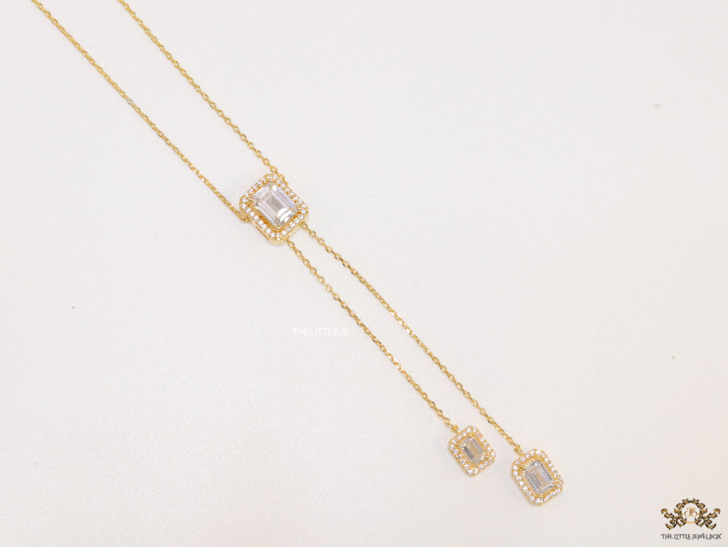 Emerald cut cubic zirconia stones in different sized on sleek gold plated chain