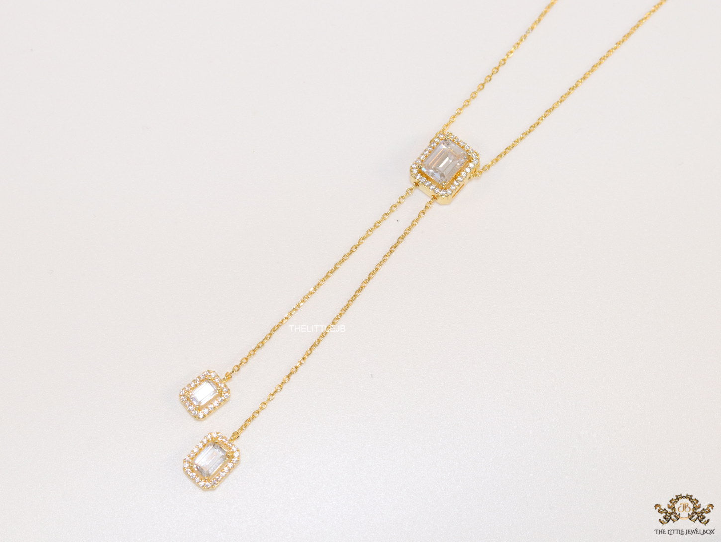 Emerald cut cubic zirconia stones in different sized on sleek gold plated chain