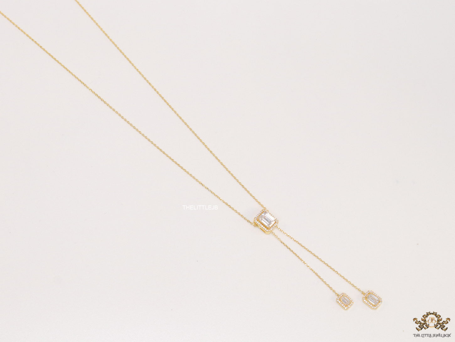 Emerald cut cubic zirconia stones in different sized on sleek gold plated chain