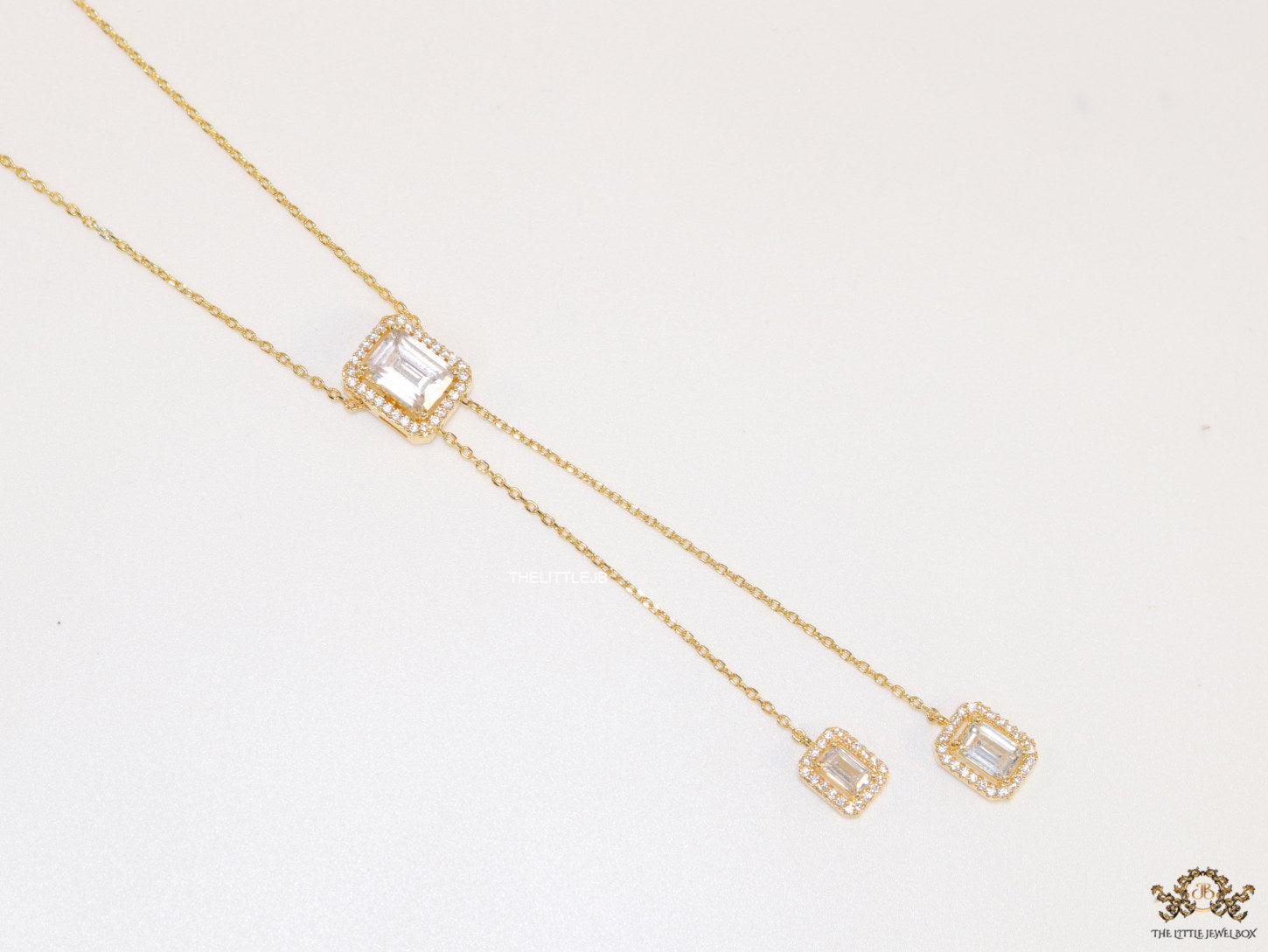 Emerald cut cubic zirconia stones in different sized on sleek gold plated chain