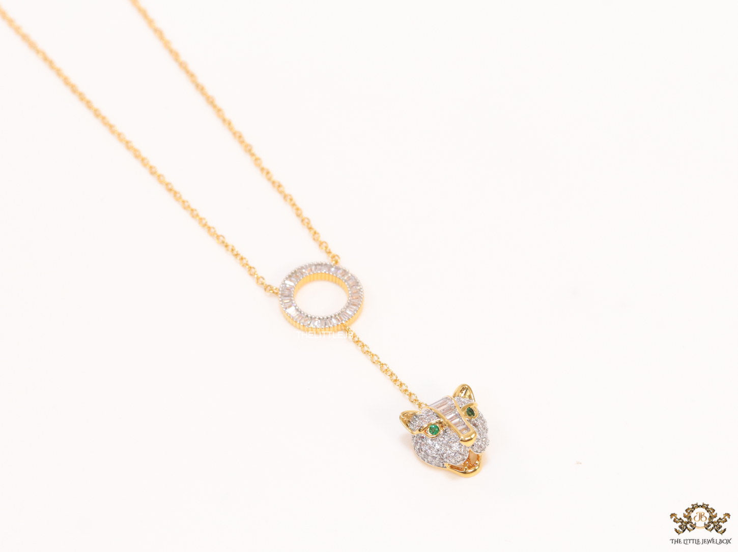 Gold plated sleek chain with circular cubic zirconia disk and gold plated panther face motif pendant