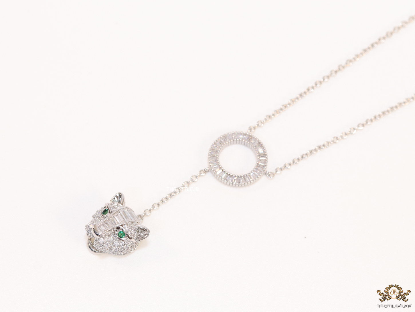 Platinum plated sleek chain with circular cubic zirconia disk and Platinum plated panther face motif pendant