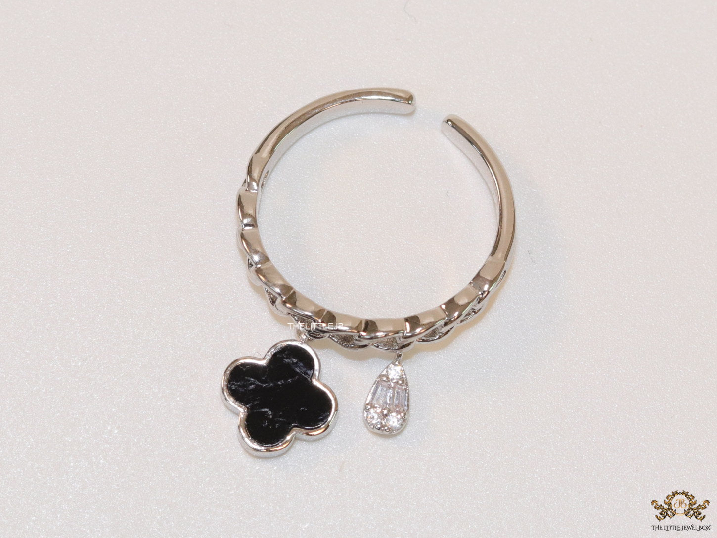 Platinum plated link chain ring with black clover and cz drop