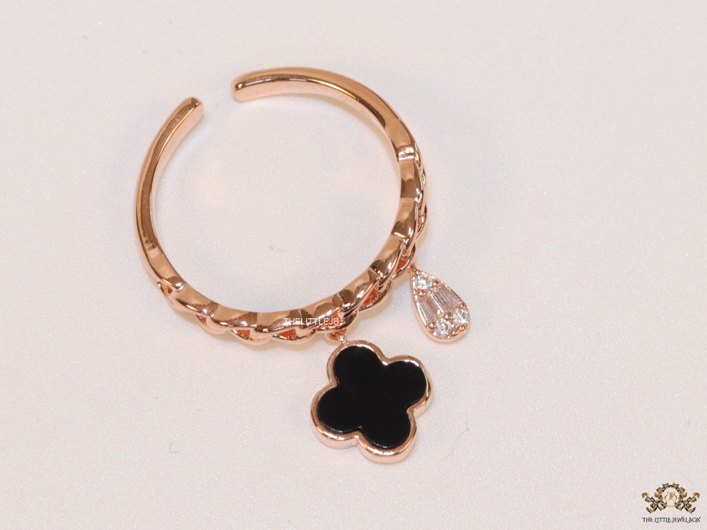 Rose gold plated link chain ring with black clover and cz drop