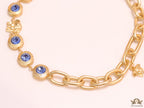 Gold plated link chain with blue cubic zirconia stones and gold plated Medusa motif charm.