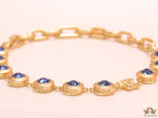 Gold plated link chain with blue cubic zirconia stones and gold plated Medusa motif charm.