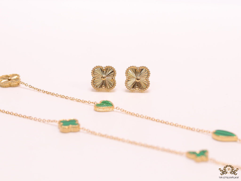 Emerald green clover heart and other shape charms on a sleek long gold plated chain with matching studs