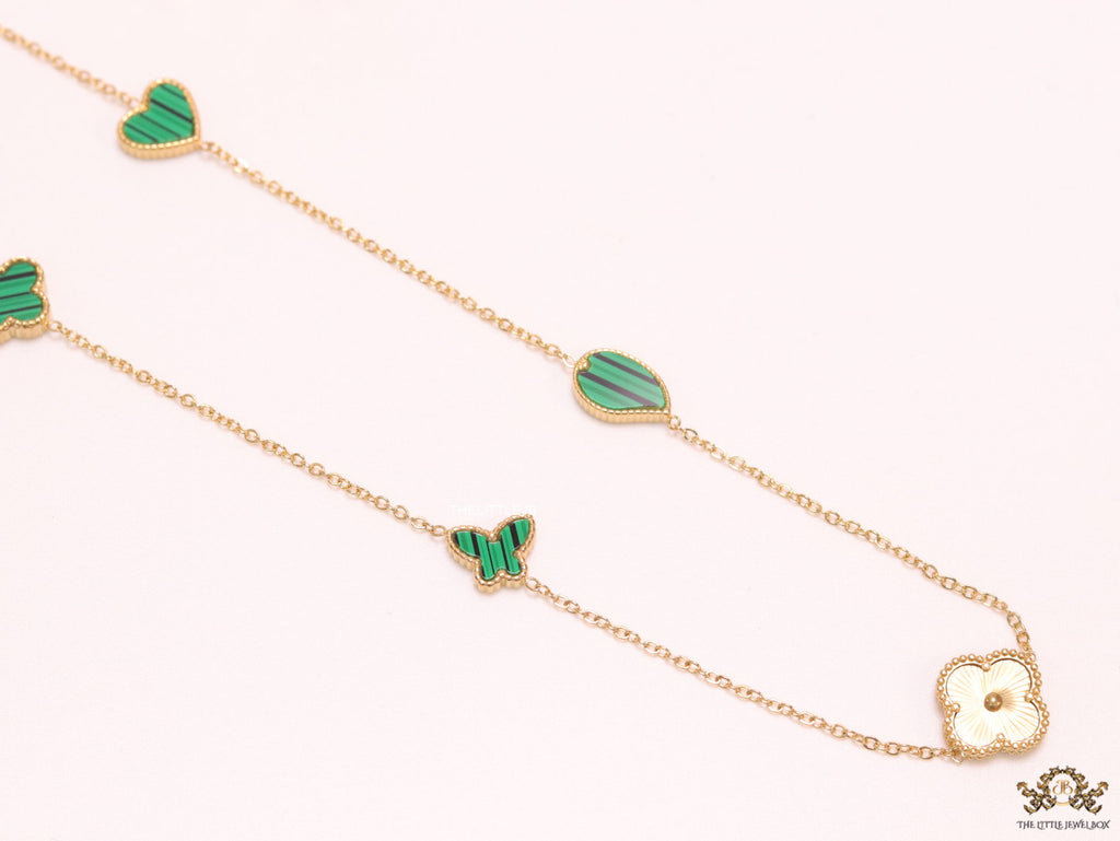 Emerald green clover heart and other shape charms on a sleek long gold plated chain with matching studs