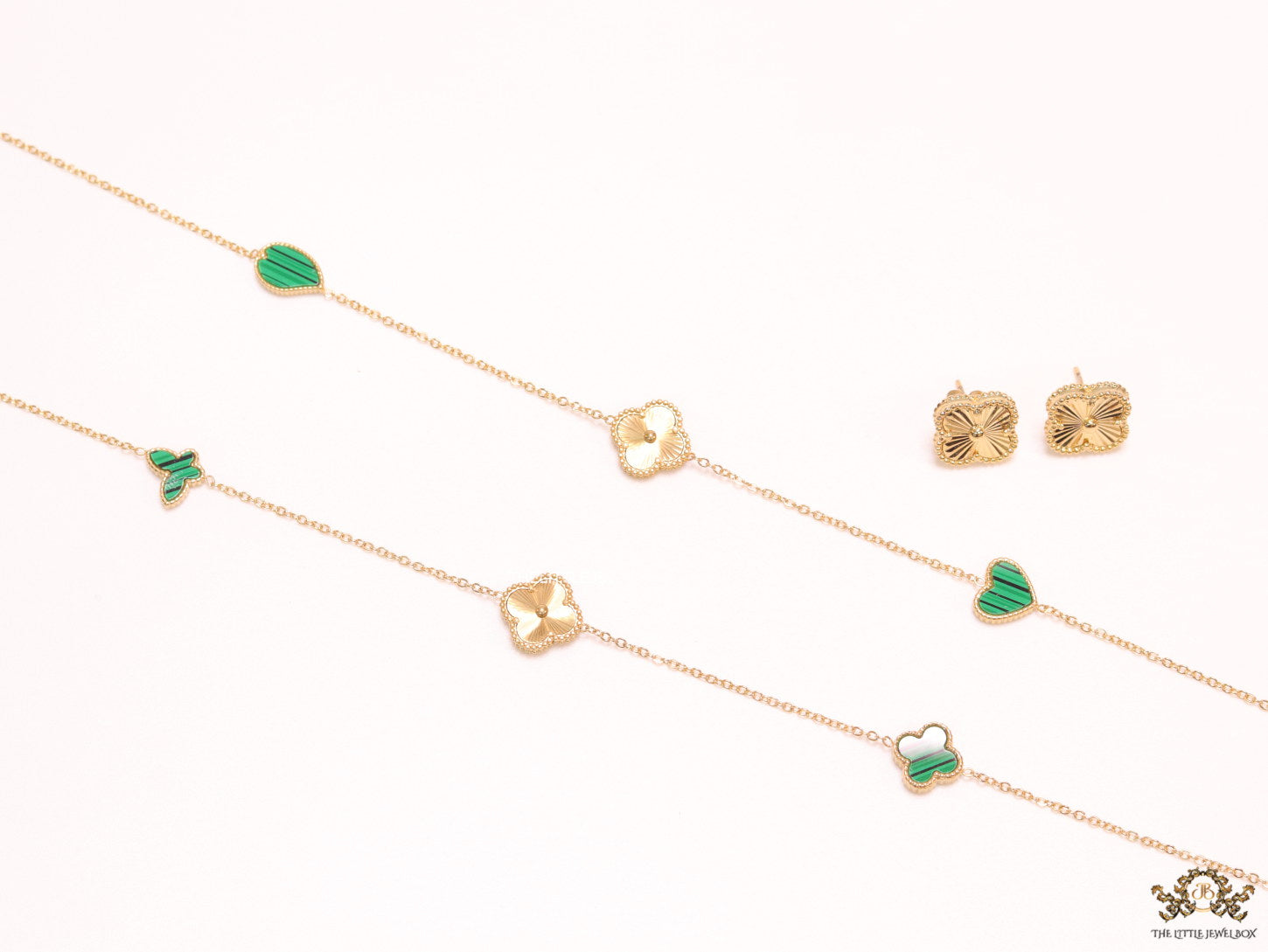 Emerald green clover heart and other shape charms on a sleek long gold plated chain with matching studs