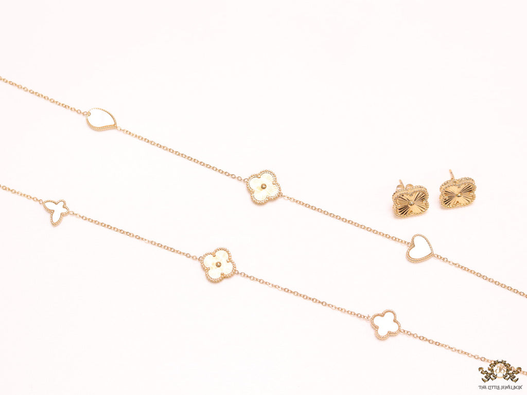 Pearl white clover heart and other shape charms on a sleek long gold plated chain with matching studs
