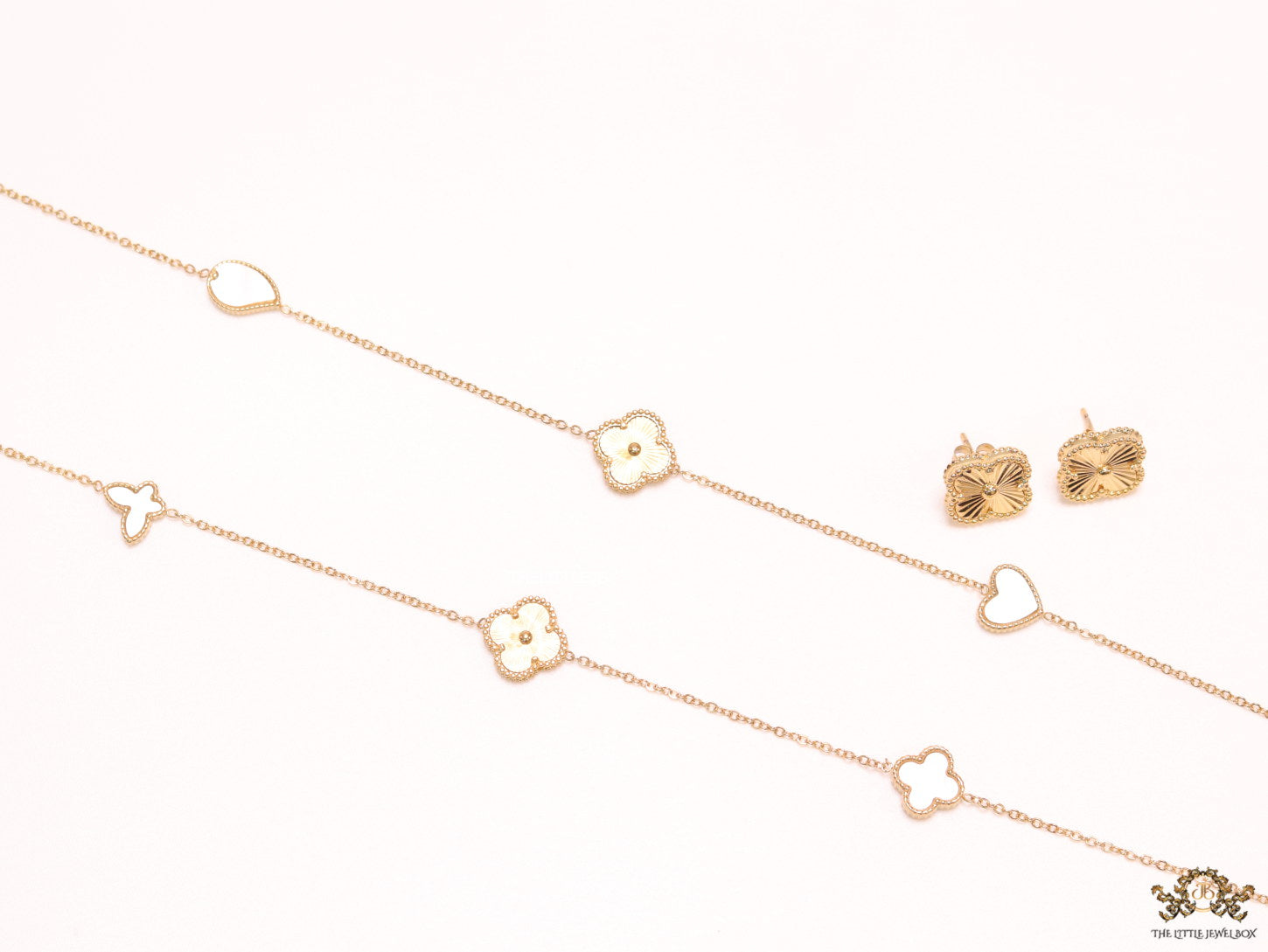 Pearl white clover heart and other shape charms on a sleek long gold plated chain with matching studs