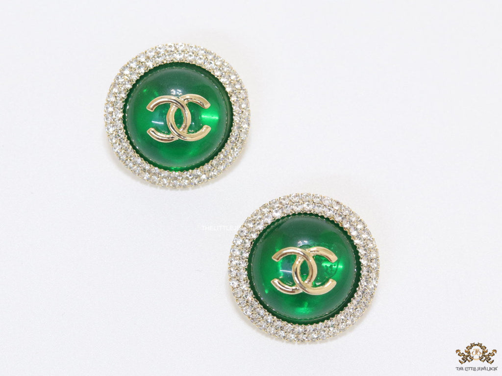 Round green stud earrings with twin C motifs lined with cz