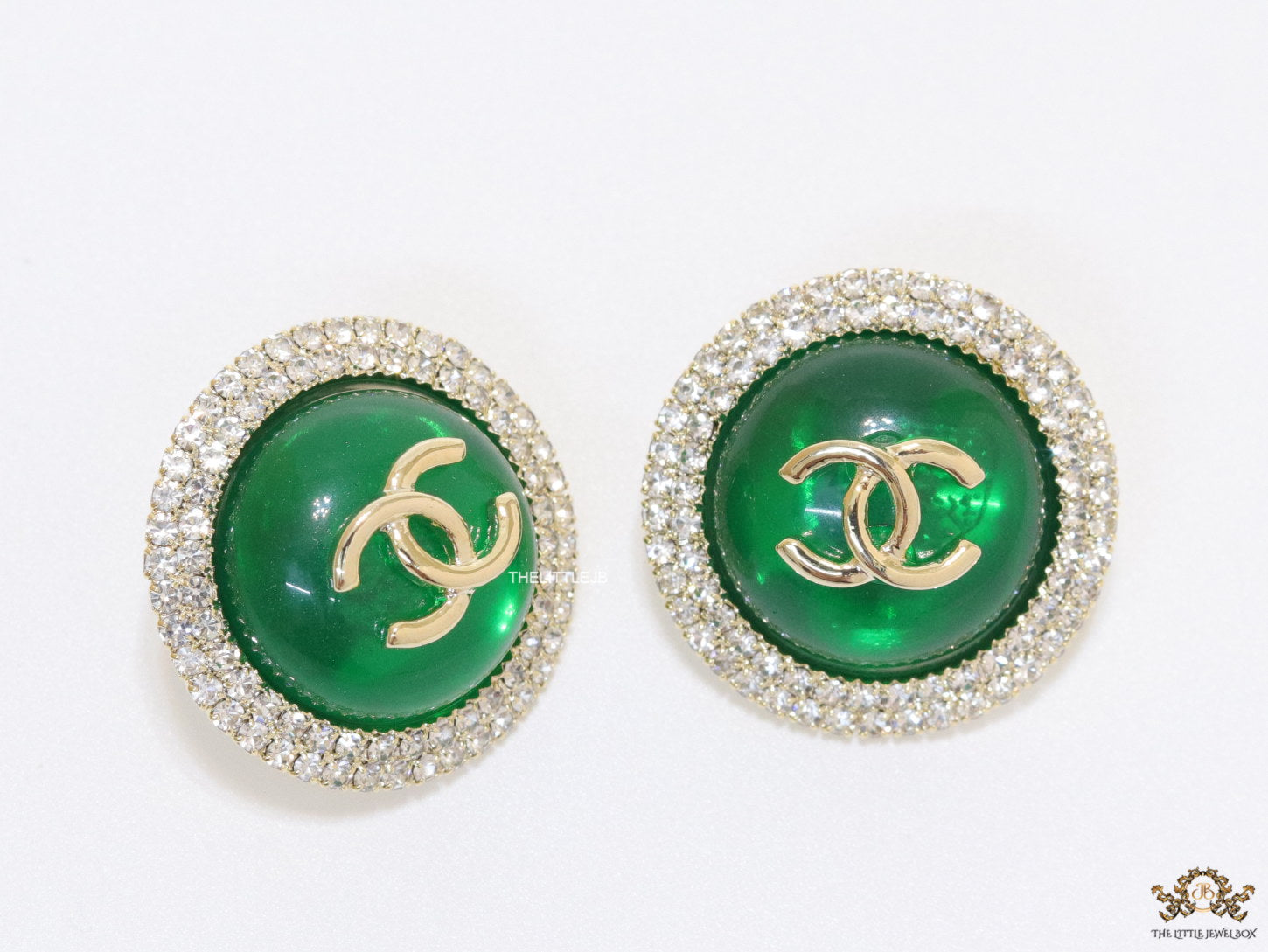 Round green stud earrings with twin C motifs lined with cz