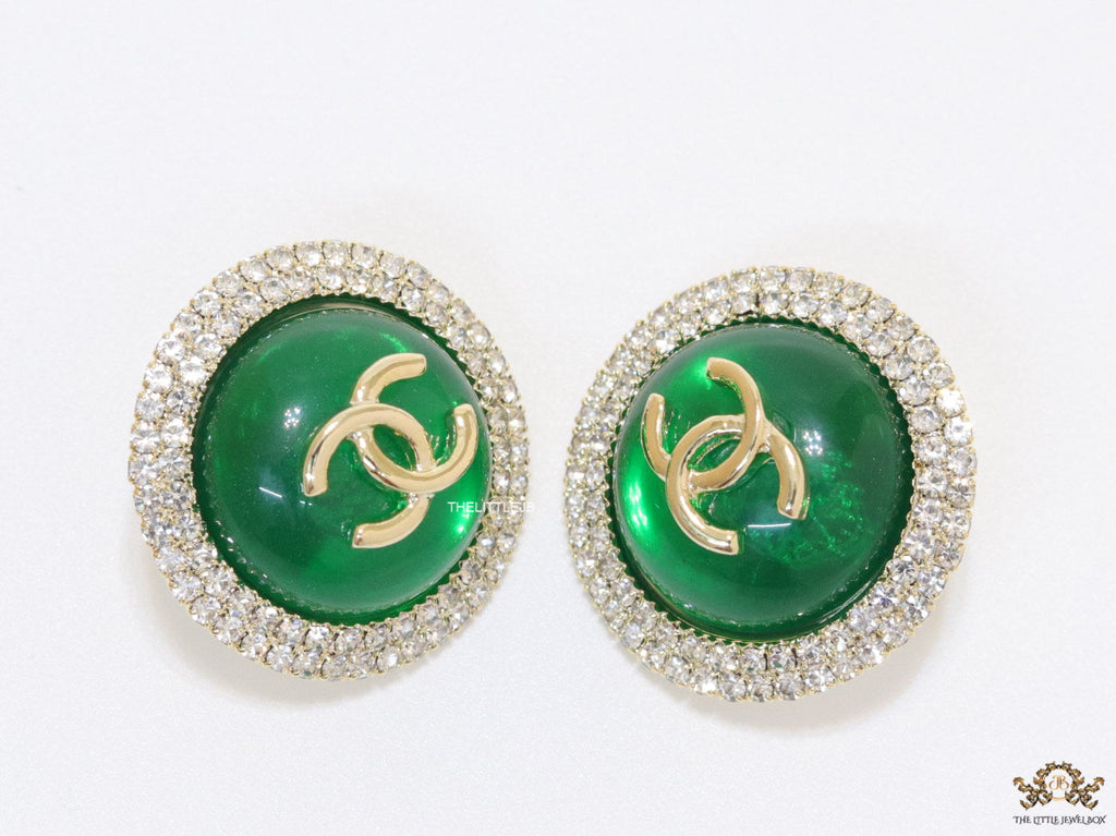 Round green stud earrings with twin C motifs lined with cz