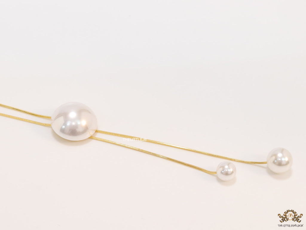 Sleek gold plated chain with different sized shell pearls.