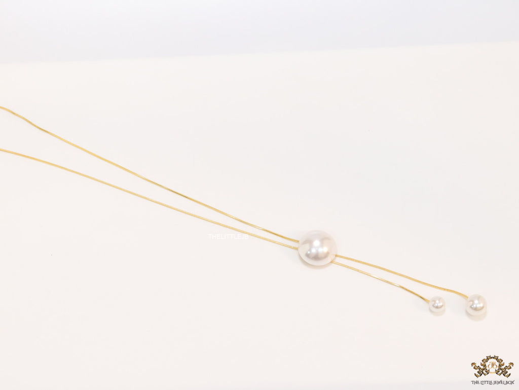 Sleek gold plated chain with different sized shell pearls.