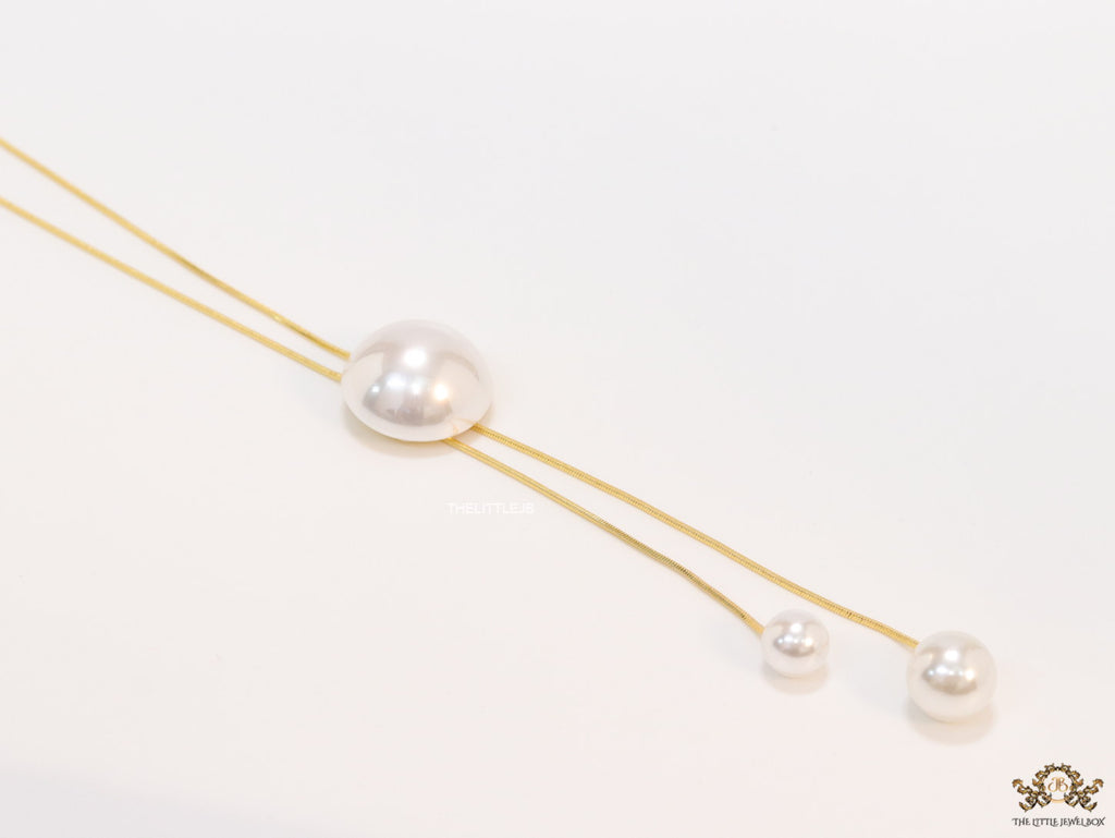 Sleek gold plated chain with different sized shell pearls.