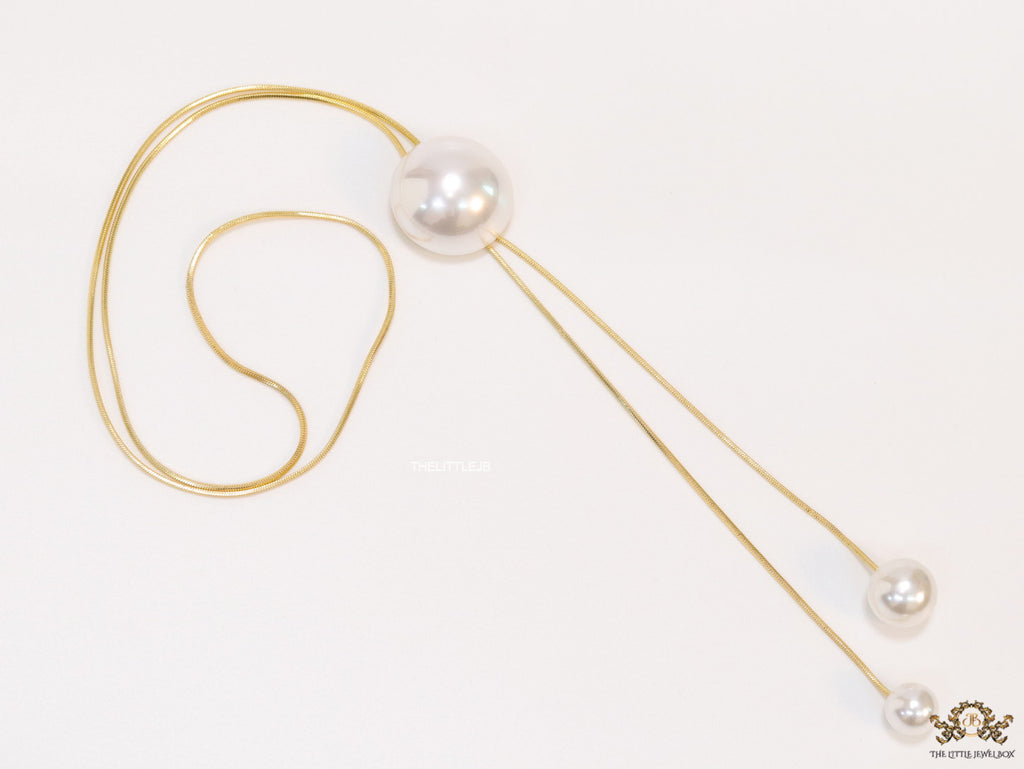 Sleek gold plated chain with different sized shell pearls.