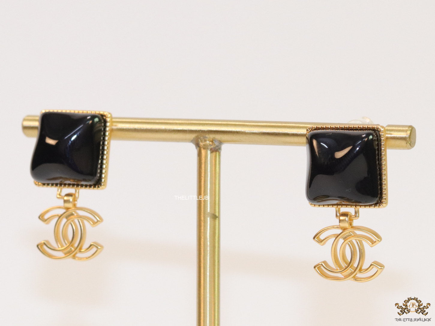 Black stone square earrings with twin C motif in gold plating
