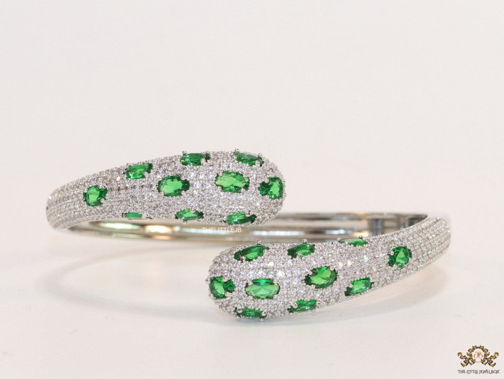 Platinum plated open cz bracelet with emerald green stones