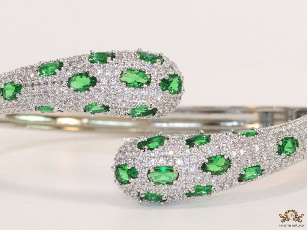 Platinum plated open cz bracelet with emerald green stones