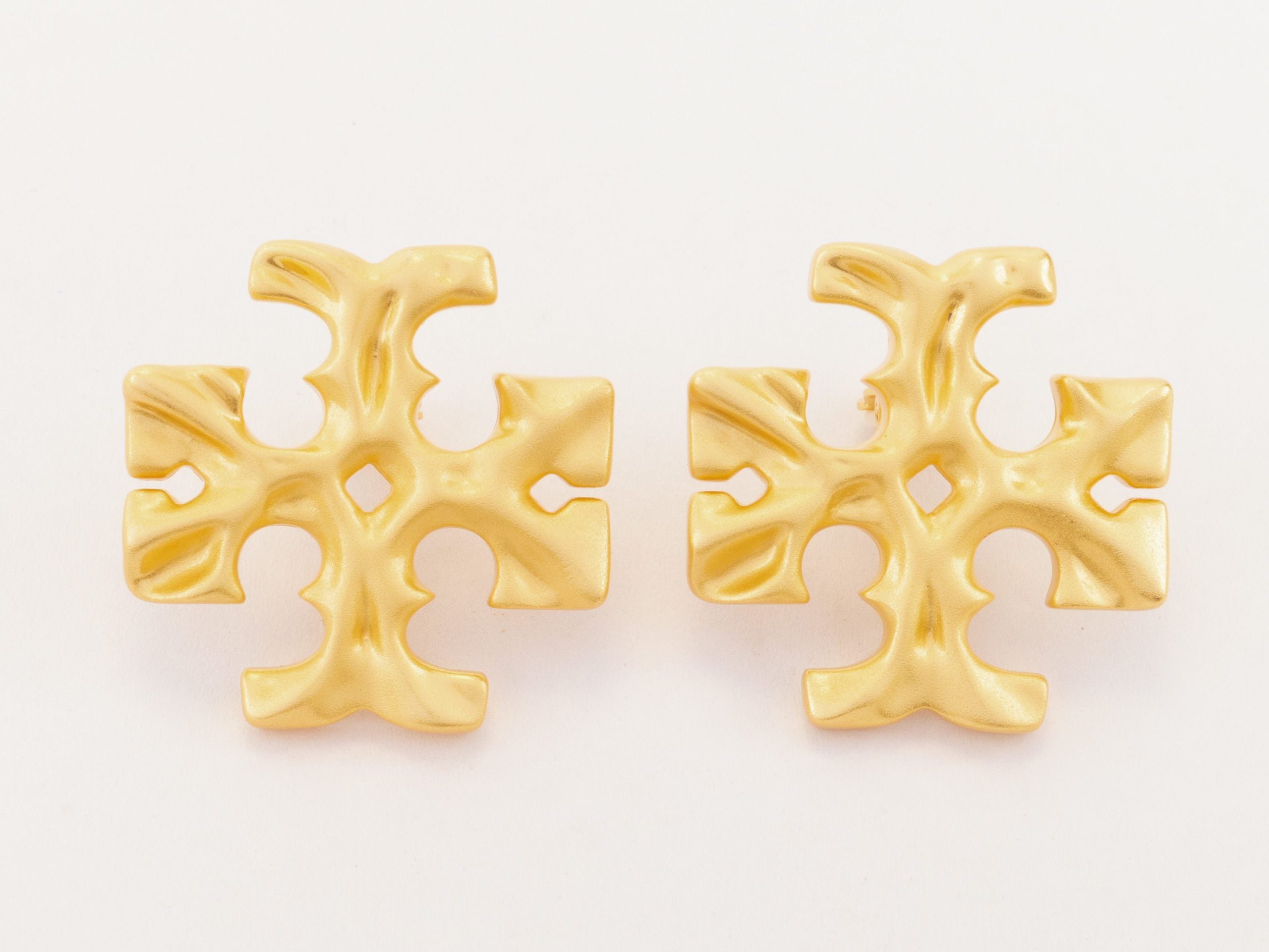 Gold earrings with T motifs matt finish clip ons