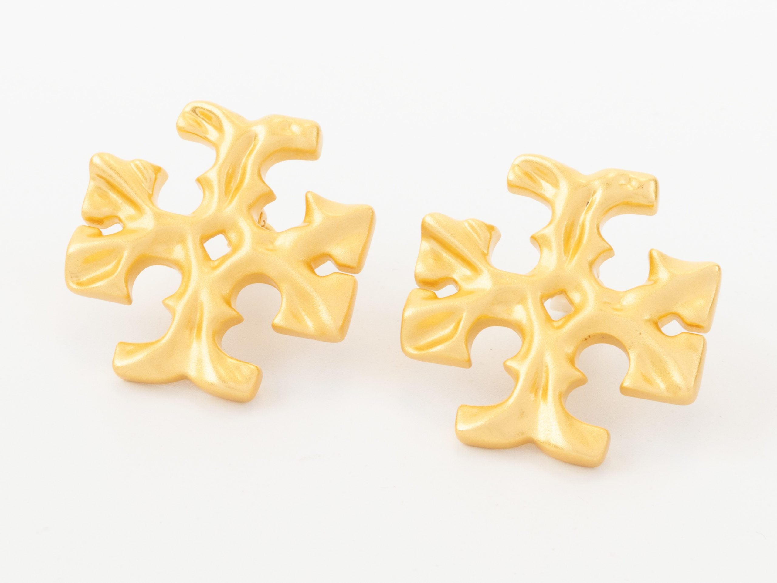 Gold earrings with T motifs matt finish clip ons