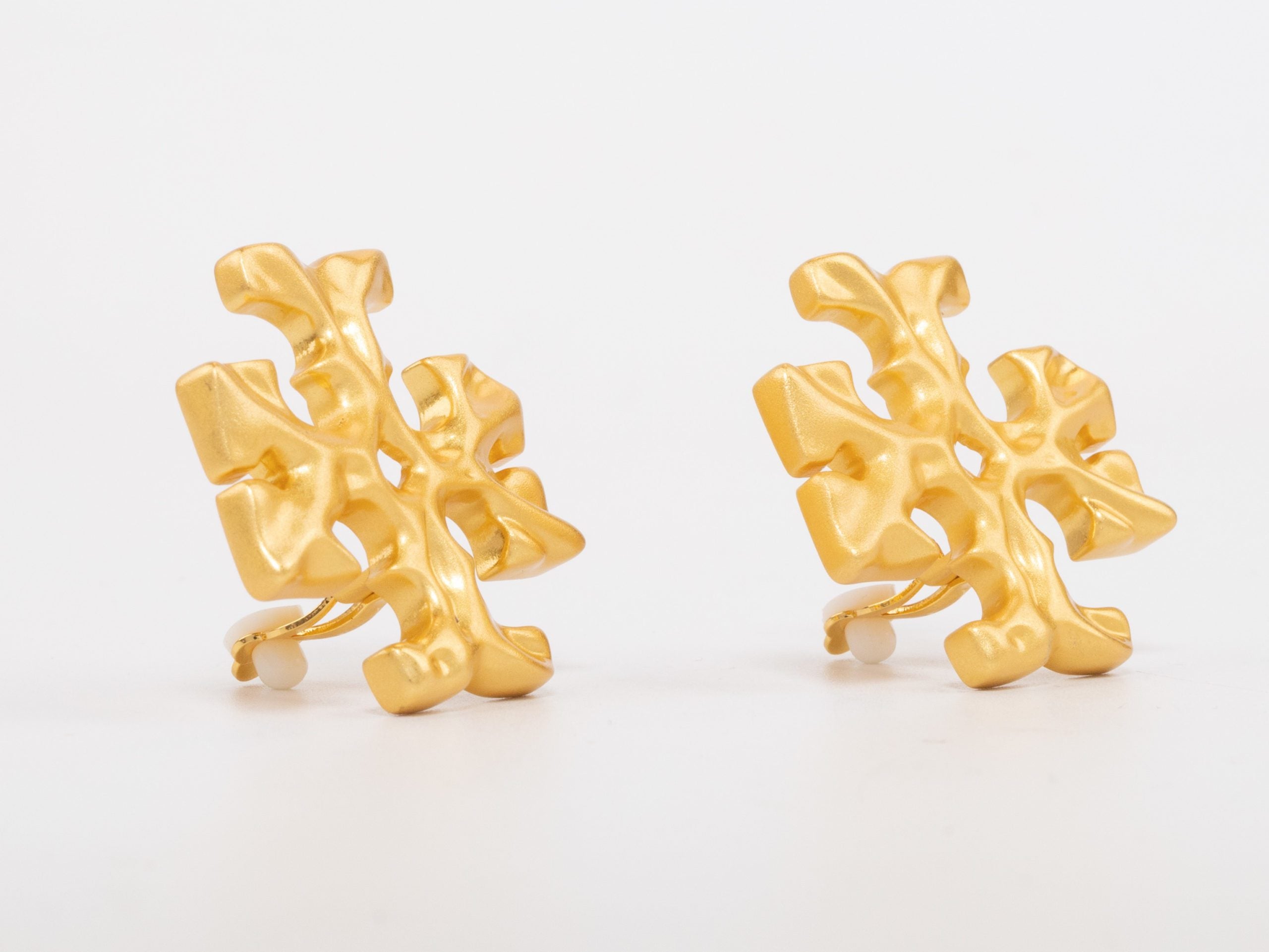 Gold earrings with T motifs matt finish clip ons