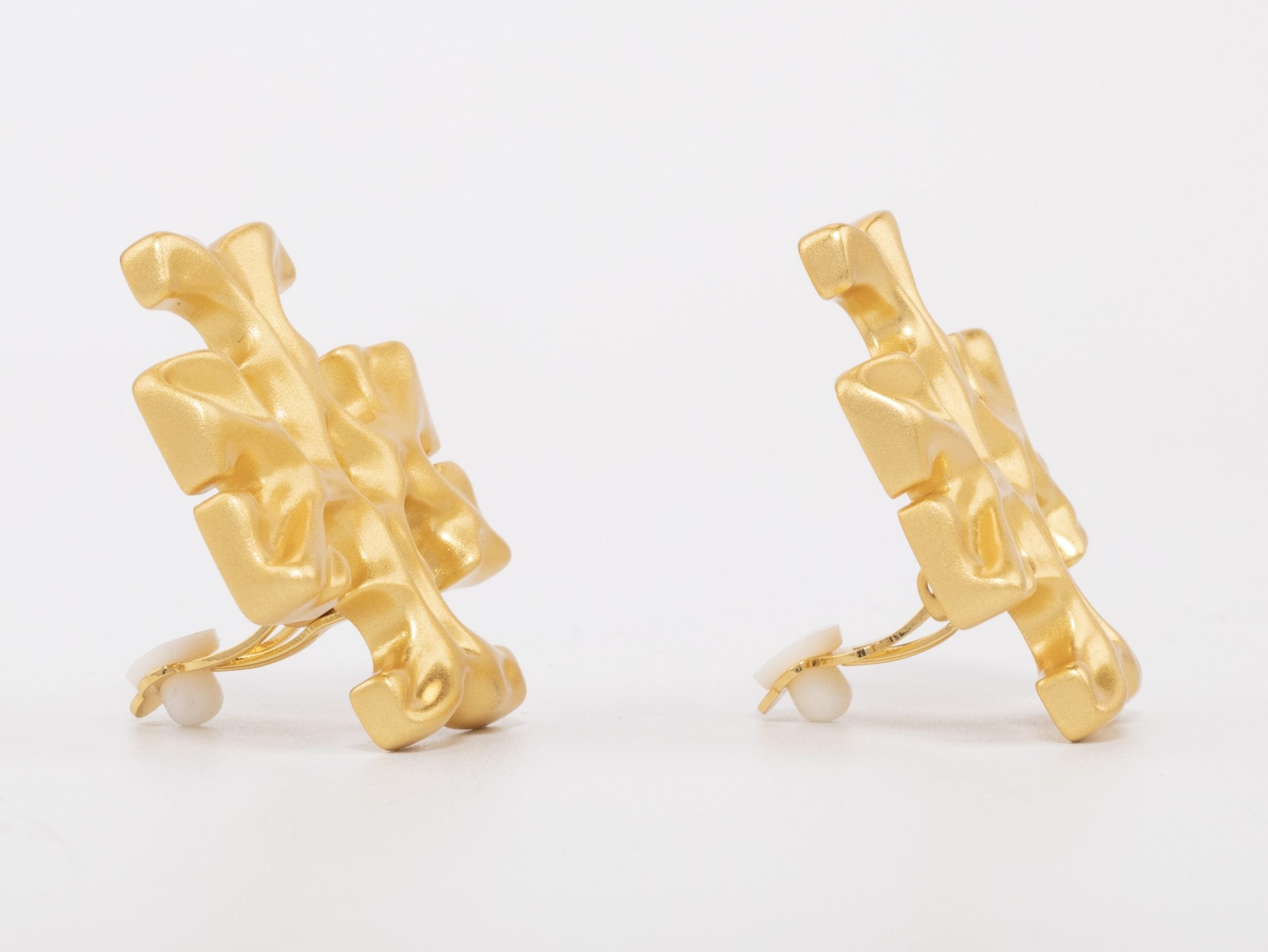 Gold earrings with T motifs matt finish clip ons