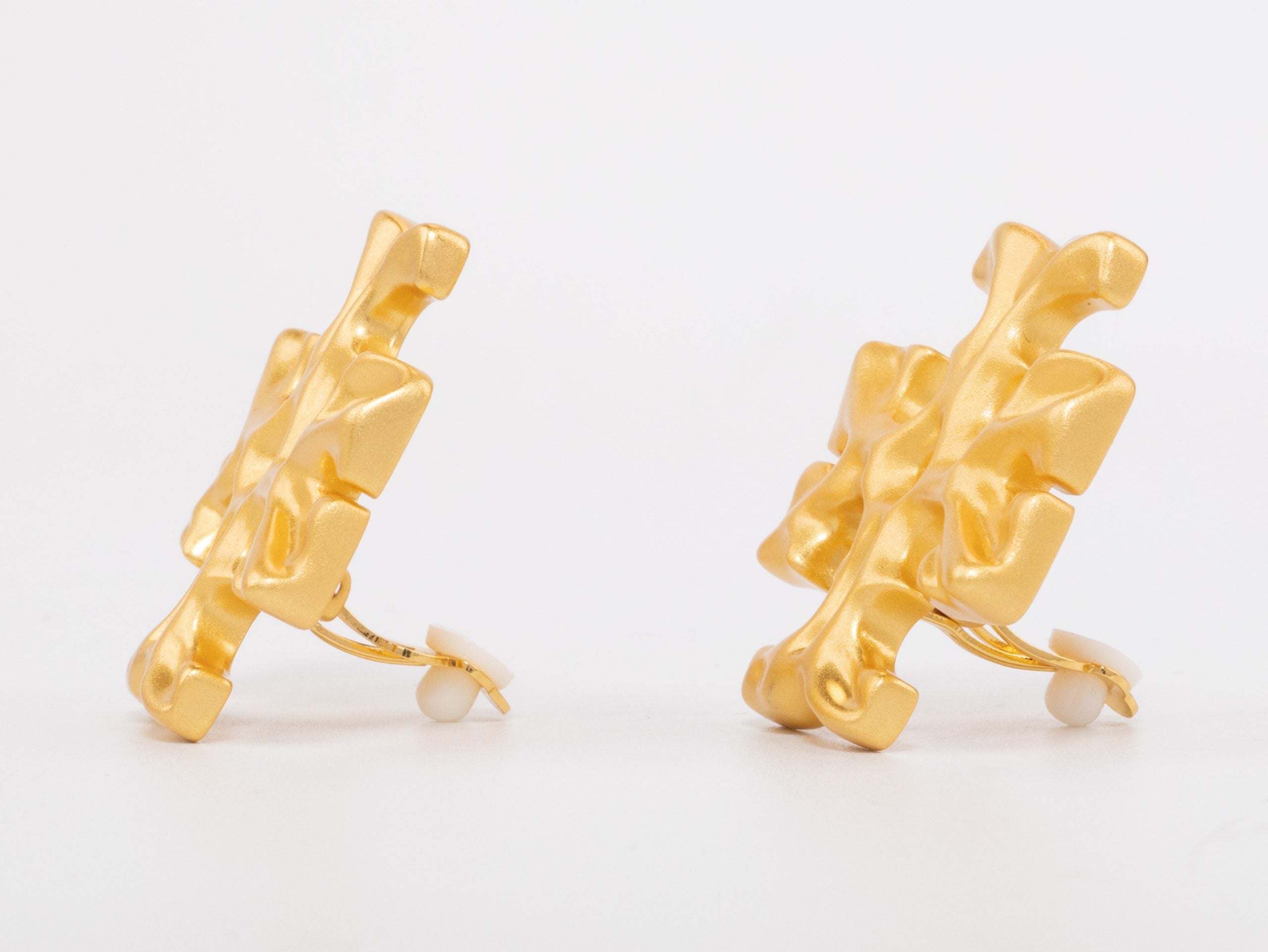 Gold earrings with T motifs matt finish clip ons