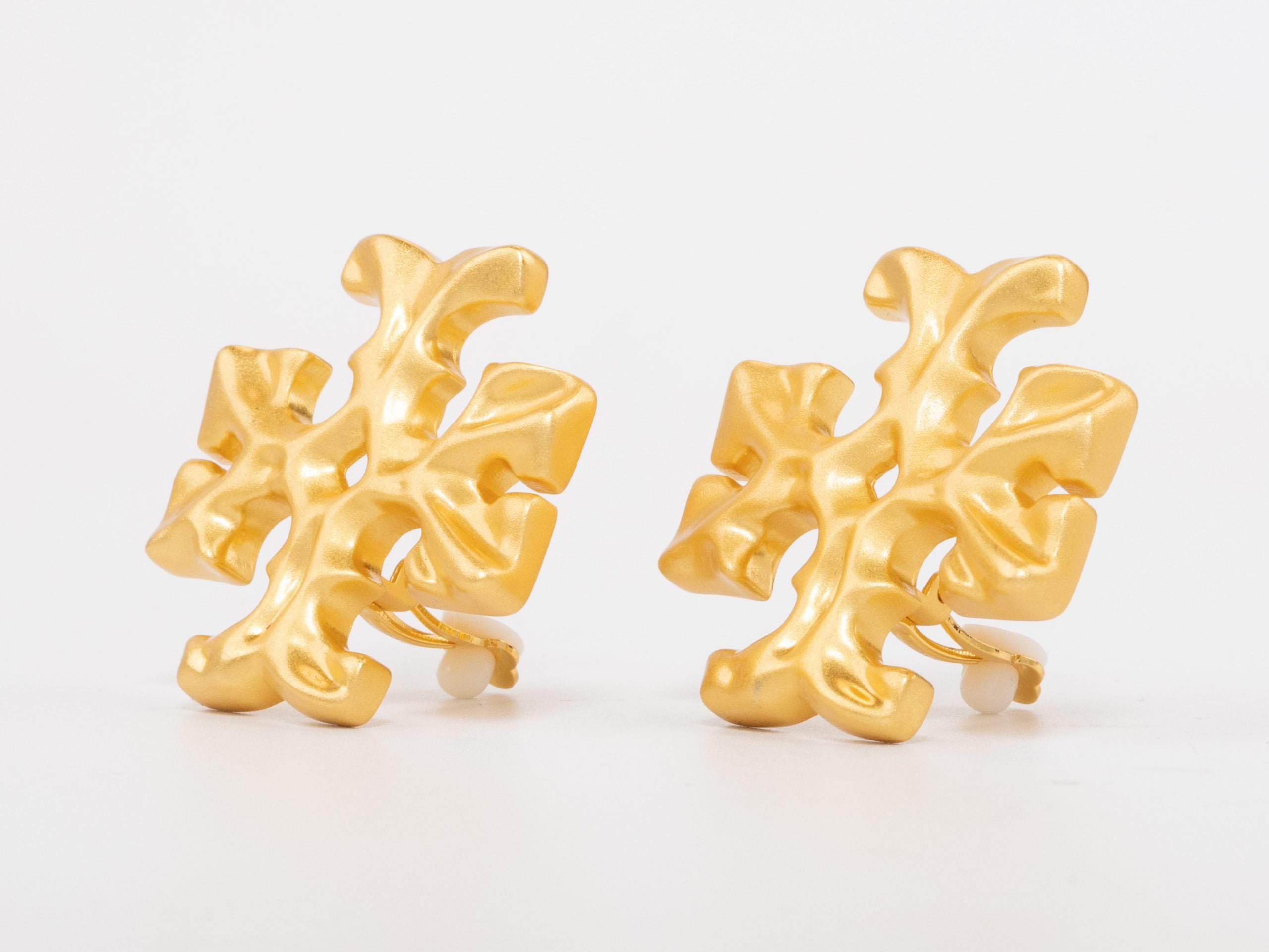Gold earrings with T motifs matt finish clip ons